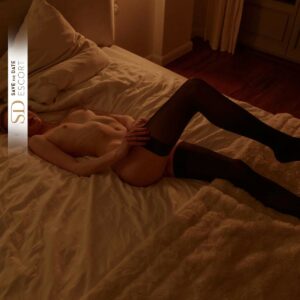 Escort Model Gigi streckt sich nackt auf dem Bett